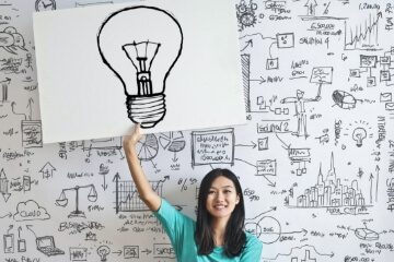 a women standing in front of a doodle wall